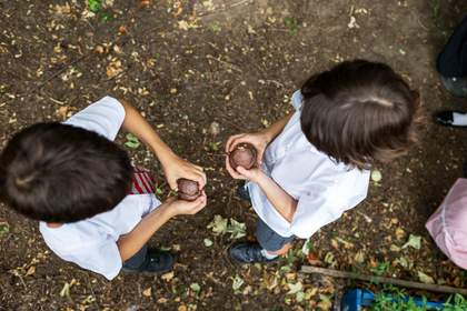 Two children in school uniform holding an object