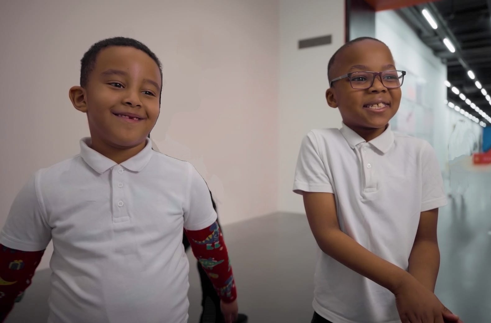 Two boys look to camera in a gallery setting